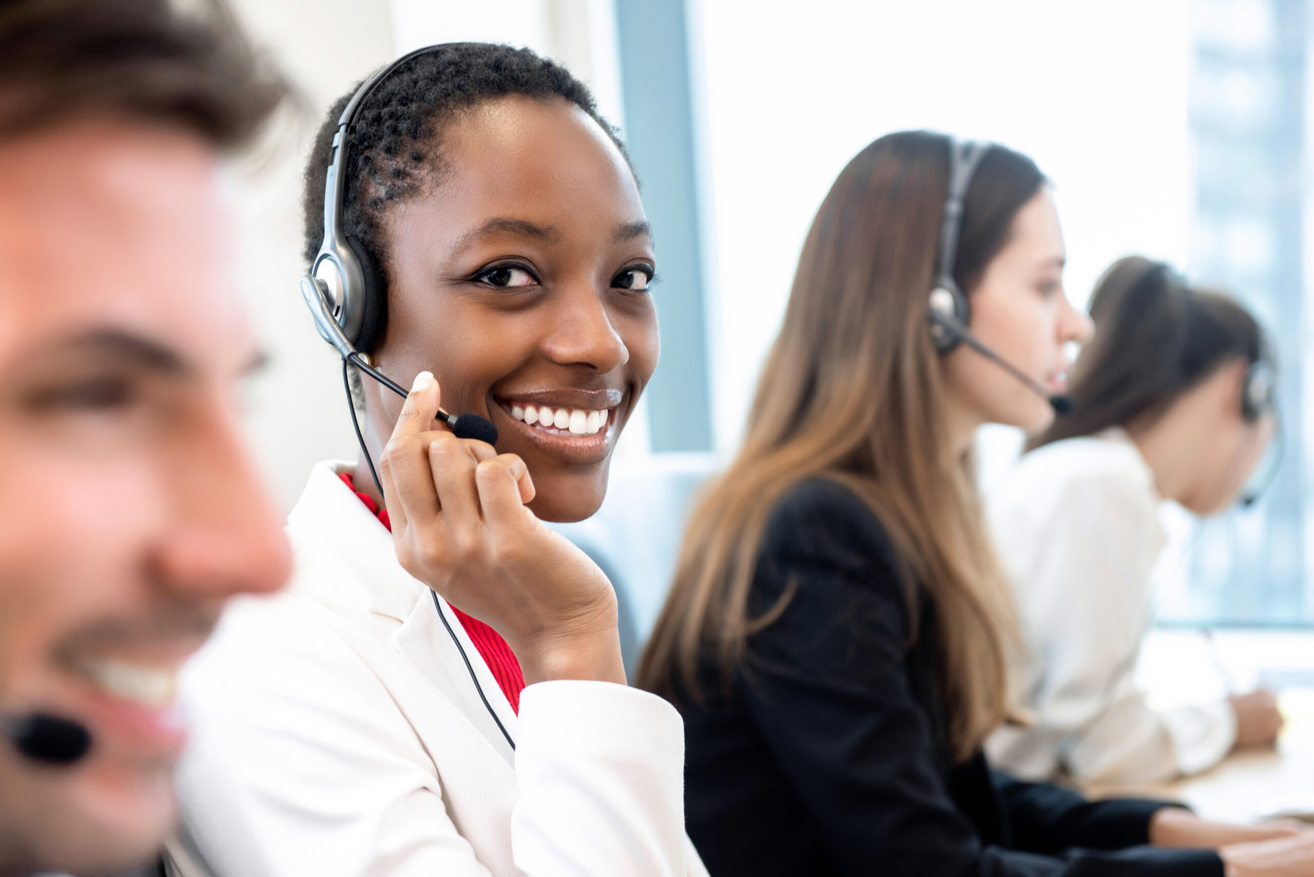 Smiling call centre agent wearing a headset at work