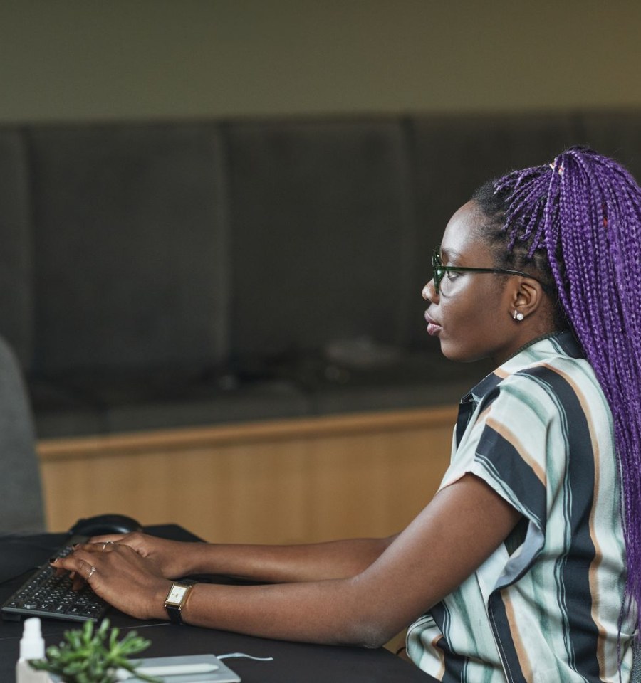 Woman typing data into a computer at an office desk