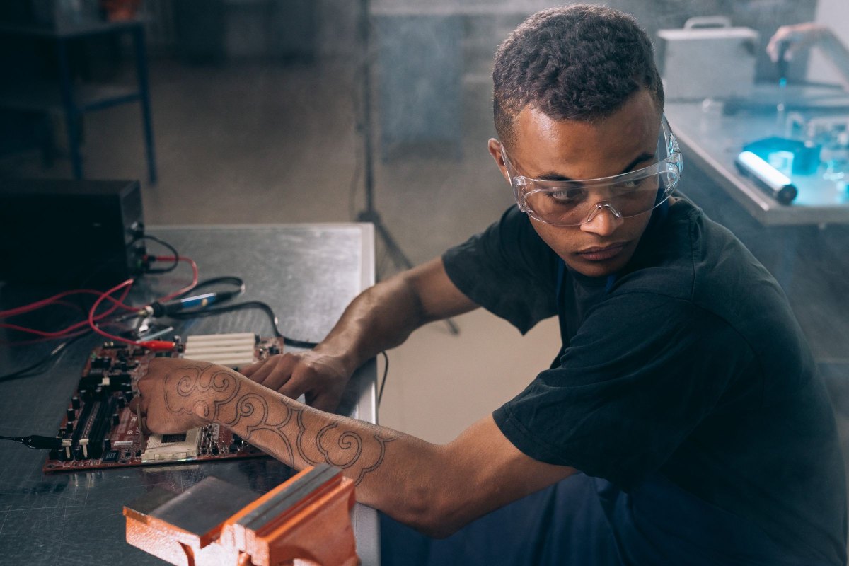 Technician repairing computer hardware at a workbench