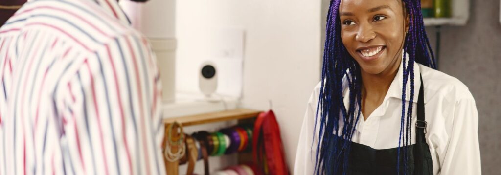 Smiling small business owner serving a customer in her shop